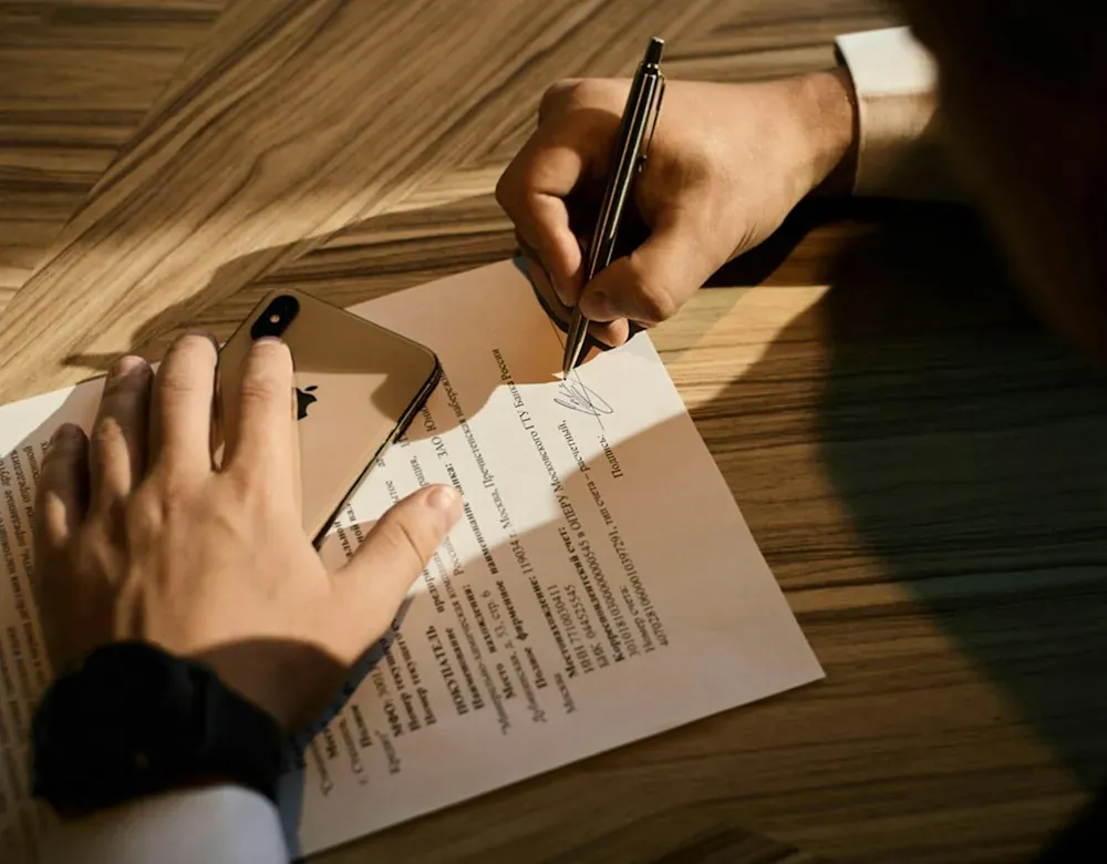 Firma de documentos de constitución sobre un escritorio de madera